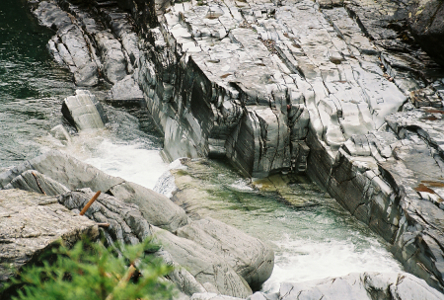 [The wet stone across which the water flows and falls is a light silver color.]